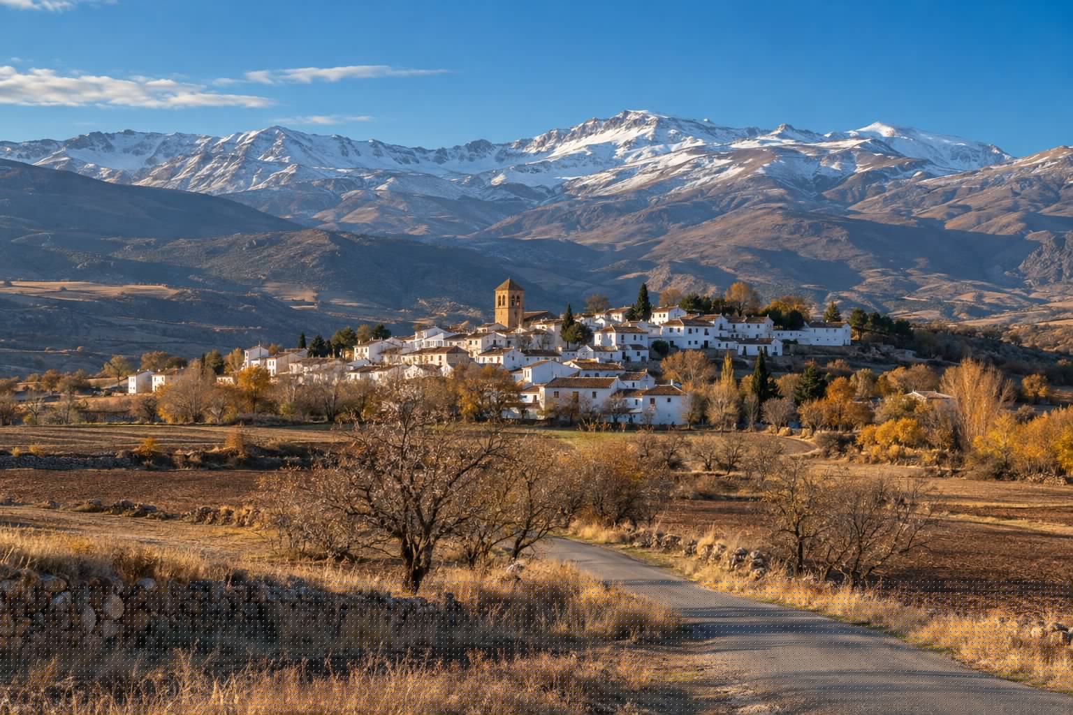 Pueblo blanco del Marquesado del Zenete con su campanario, al pie de Sierra Nevada en una mañana de otoño (imagen ilustrativa)